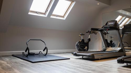 a gym with two treadmills and two exercise bikes at voco Oxford Thames by IHG in Oxford