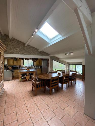 une grande cuisine avec une table et des chaises. dans l'établissement Domaine de La Michelle, à Madaillan