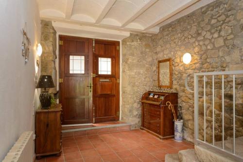 a hallway with a door and a stone wall at Can Mieta in Bas