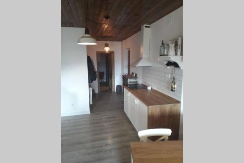 a kitchen with white cabinets and a wooden floor at Can Mieta in Bas