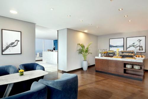 a restaurant with blue chairs and a counter with food at voco Dubai by IHG in Dubai