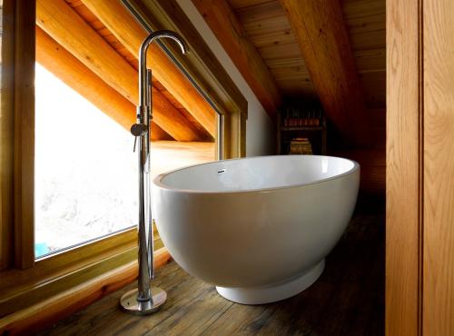 a white bath tub in a room with a window at Caledonian Cabin in Invergarry