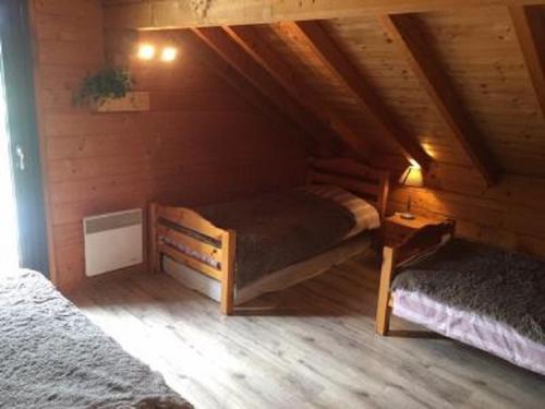 um quarto com 2 camas num chalé de madeira em Chalet Le Roncing em Gérardmer