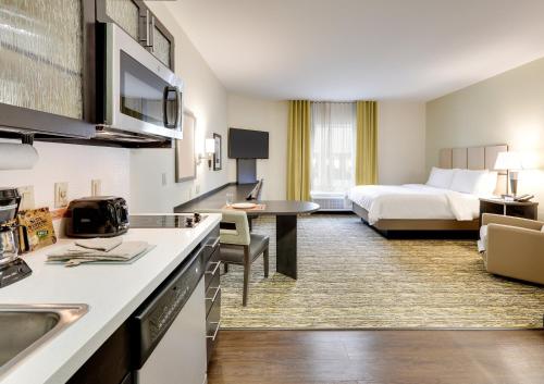 a hotel room with a kitchen and a bed at Candlewood Suites Dallas NW - Farmers Branch, an IHG Hotel in Farmers Branch