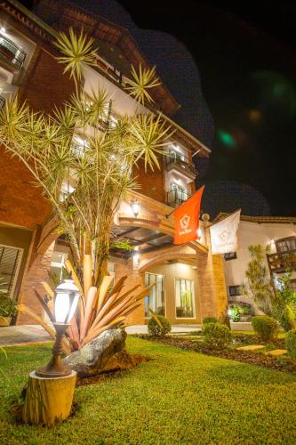 a house with a tree in front of it at LENA ROSA Premium Hotel in Pomerode