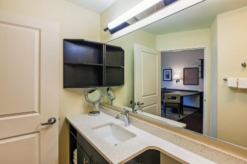 a bathroom with a sink and a mirror at Candlewood Suites Lenexa - Overland Park Area by IHG in Lenexa