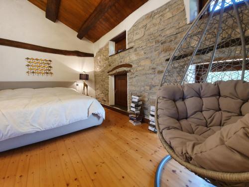 1 dormitorio con cama colgante y pared de piedra en Millefiori Suite&Room, en Lago
