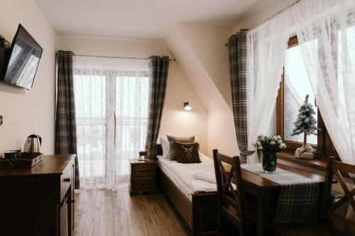 a bedroom with a large window and a large bed at Willa Góralski Styl in Bukowina Tatrzańska