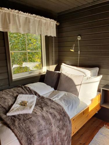 um quarto com uma cama grande e uma janela em Yggdrasil Farmhotel Retreat, Spa & Yoga em Straumsbukta