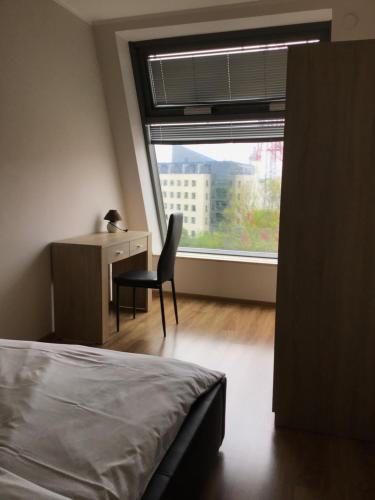 - une chambre avec un lit, un bureau et une fenêtre dans l'établissement Młynowa - Apartamenty Centrum New, à Białystok