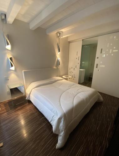a bedroom with a large white bed in a room at Welcome Traveller ATMOSPHERE APARTMENT in Bardolino