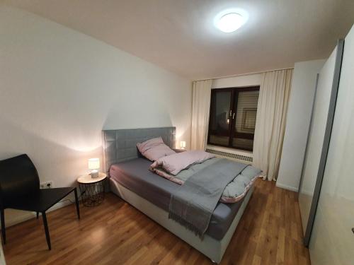 ラーティンゲンにある2-Zimmer-Apartment Ratingen Ostのベッドルーム1室(ベッド1台、椅子、窓付)