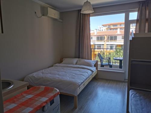 a small bedroom with a bed and a large window at PERSANI 3 SUNNY BEACH in Sunny Beach