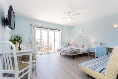 a bedroom with a bed and a table and a desk at Mariners (2) - Bright and stylish apartment - walk to the beach in Luz