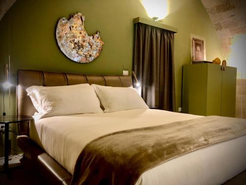 a bedroom with a large bed and a green wall at Masseria Li Reni in Manduria