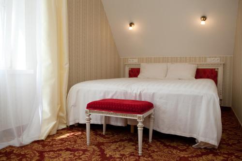 a bedroom with a white bed with a red seat at Ööbikuoru Villa in Rõuge