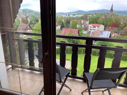 a balcony with chairs and a view of a city at DOM KKK in Rabka