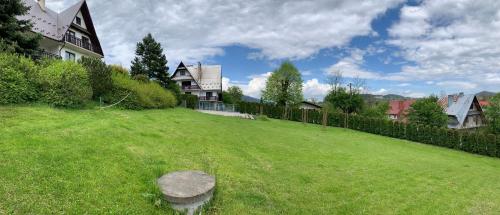 a large grassy yard with a house on top of it at DOM KKK in Rabka-Zdrój