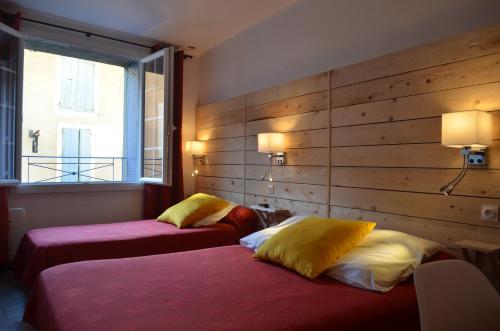 2 Betten in einem Hotelzimmer mit Fenster in der Unterkunft Hôtel Restaurant Panoramique César in Bonnieux