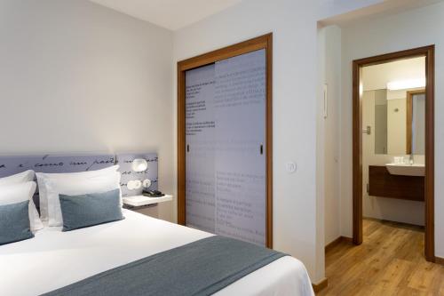 a bedroom with a large screen behind a bed at Hotel das Salinas in Aveiro