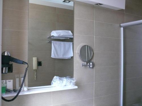 a bathroom with a shower with a mirror and a phone at Hotel Los Angeles in Guarnizo