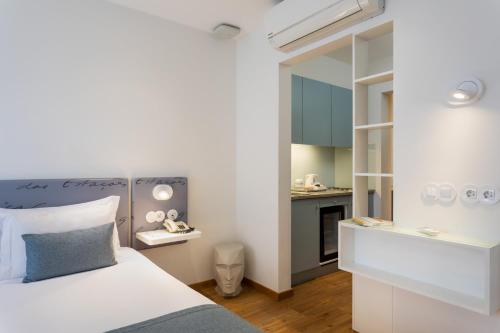 ein Schlafzimmer mit einem Bett und eine kleine Küche in der Unterkunft Hotel das Salinas in Aveiro