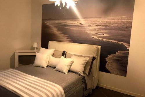 a bedroom with a bed with a painting of the ocean at Luna27 in Toscolano Maderno