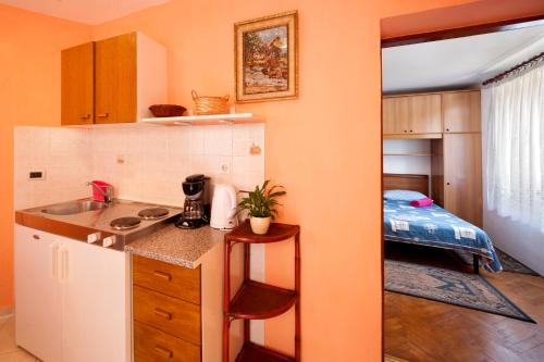 a kitchen with a sink and a room with a bed at Apartment Brle in Poreč