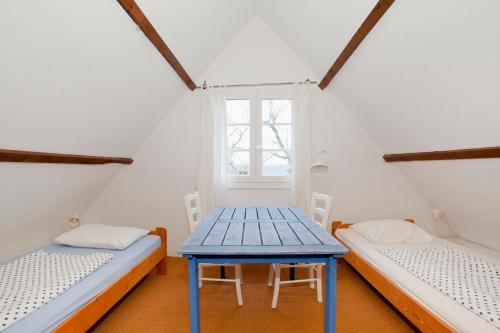 a room with two beds and a blue table at Domaine de Gayfié in Salvagnac-Cajarc