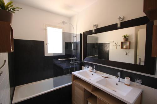 une salle de bain avec un lavabo et un miroir dans l'établissement Villa Les Albizias, à Cavalaire-sur-Mer