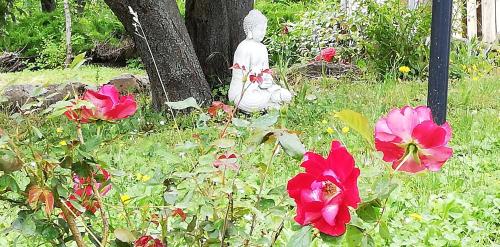 a small statue sitting in the grass next to flowers at B&B Caselunghe in Camerino