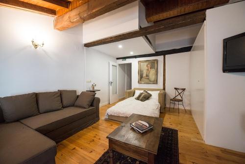 - un salon avec un canapé et un lit dans l'établissement Heart of Pamplona Apartments I, à Pampelune