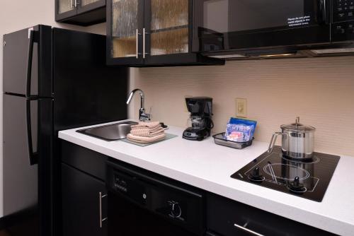 a kitchen with a sink and a stove top oven at Candlewood Suites Morgantown-Univ West Virginia by IHG in Morgantown