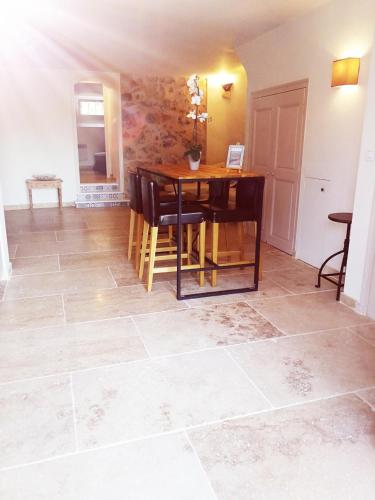 a dining room with a table and chairs on a tile floor at Bastide Provençale Les Mûriers d'Engaspaty in Seillans
