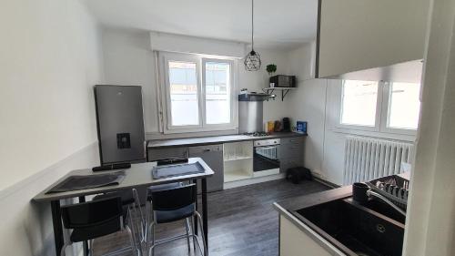 - une cuisine avec un comptoir et des chaises dans l'établissement Joli T2- centre ville - Parking gratuit - WIFI, à Dunkerque