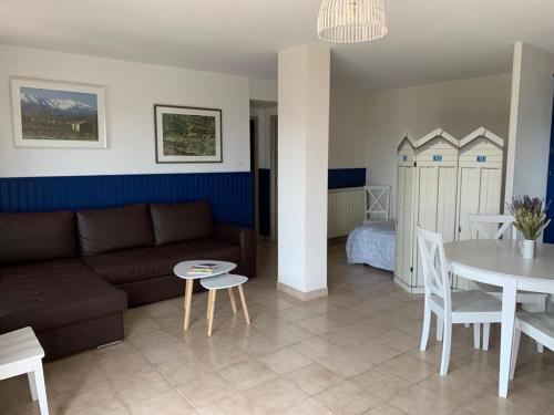 un salon avec un canapé, une table et un lit dans l'établissement Le Domaine Vermeil, à Argelès-sur-Mer