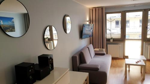 sala de estar con sofá y 2 espejos en Apartament Opal Zdrojowa 300m do morza, en Świnoujście