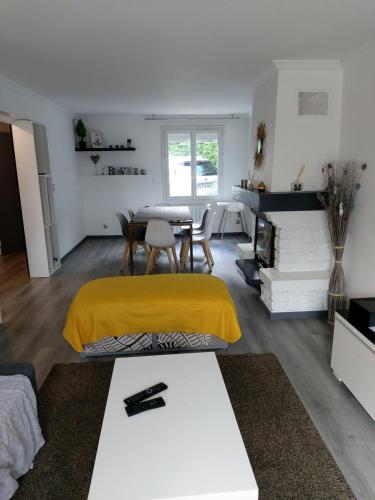 ein Wohnzimmer mit einem Tisch und einer gelben Decke in der Unterkunft Disneyland/Paris 1 a10 personnes climatisee in Pontault-Combault