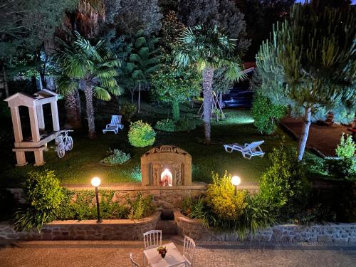 a garden at night with a fireplace and palm trees at Turismo Homes Solar Do Areal in Braga