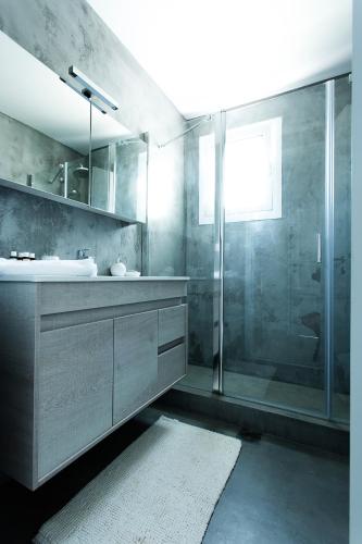 a bathroom with a shower and a sink at Sun 'n Chill, Boutique Apartments & Beach Villa in Melíkia