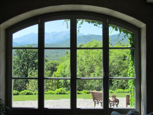 ein Fenster mit Blick auf eine Bank und die Berge in der Unterkunft Le Maddalene B&B in Avigliana