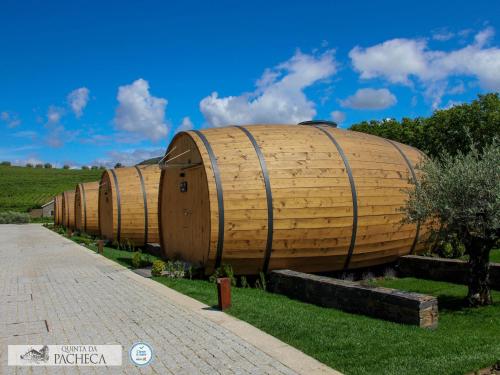 a row of wooden barrels sitting on the grass at Pacheca The Wine House Hotel e Spa - Quinta da Pacheca in Lamego