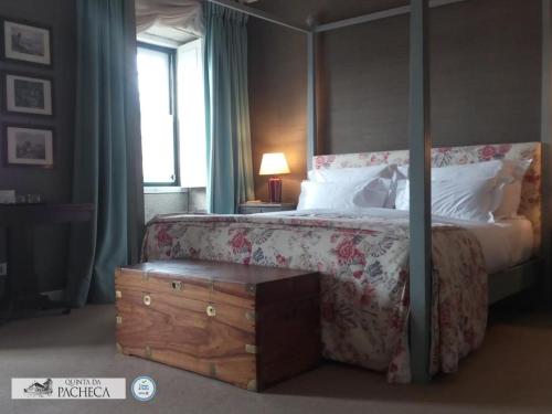 a bedroom with a canopy bed with a dresser and a window at Pacheca The Wine House Hotel e Spa - Quinta da Pacheca in Lamego