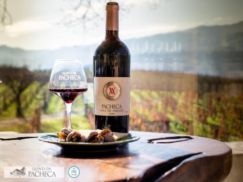 a bottle of red wine and a plate of food at Pacheca The Wine House Hotel e Spa - Quinta da Pacheca in Lamego