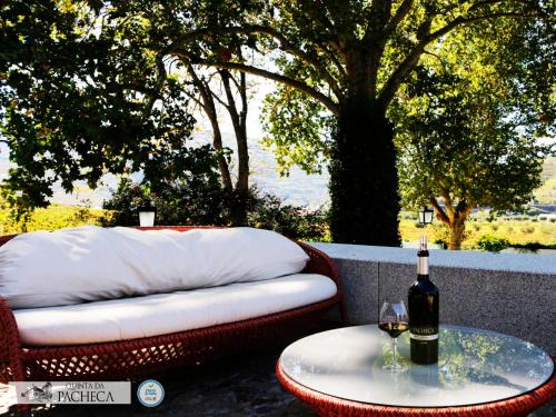 a bottle of wine sitting on a table next to a couch at Pacheca The Wine House Hotel e Spa - Quinta da Pacheca in Lamego