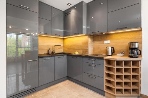 cocina con armarios grises y paredes de madera en Happy Stay OldNova Deluxe Apartment 366, en Gdansk