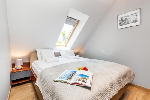 Un dormitorio con una cama con dos libros encima. en Happy Stay OldNova Deluxe Apartment 366, en Gdansk