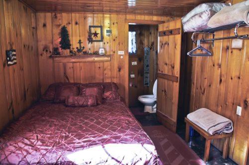 a bedroom with a large bed in a wooden room at Cabin #8 - Mackinac Point cabin in Carp Lake