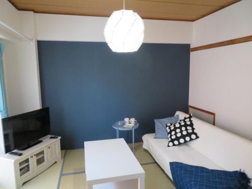 a living room with a blue accent wall at 札幌市中心部大通公園まで徒歩十分観光移動に便利なロケーションh507 in Sapporo