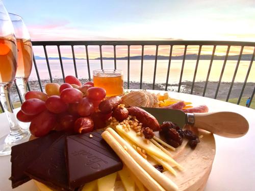 a plate of food on a table with wine and grapes at Boulevard Waters in Taupo